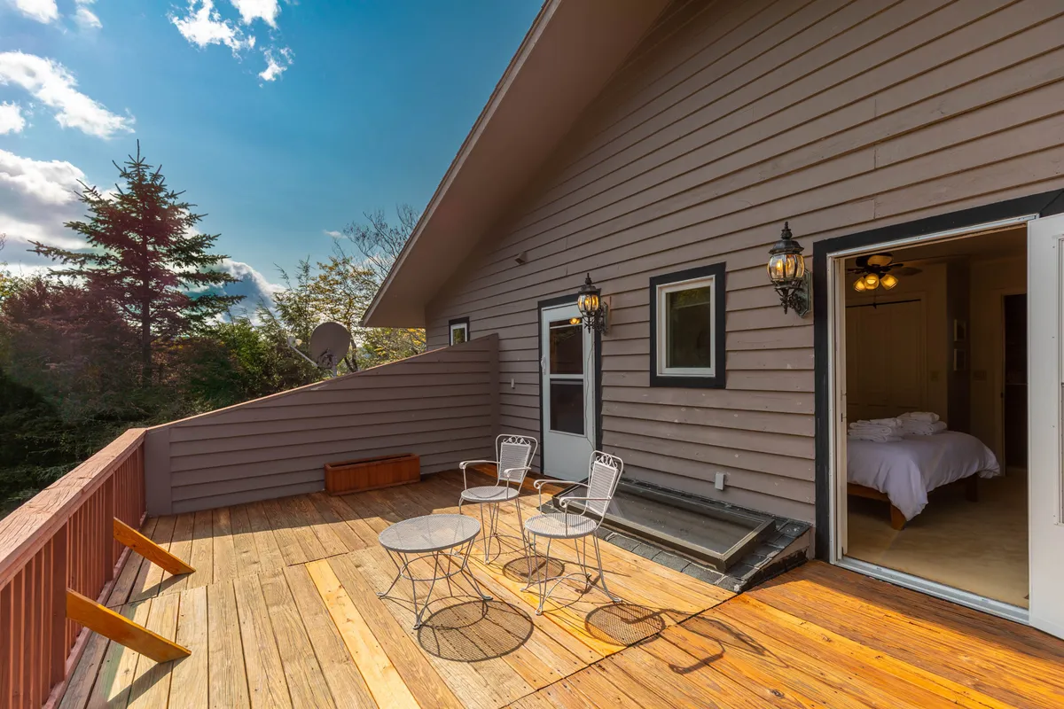 A peaceful deck area with comfortable outdoor seating and direct access to the surrounding landscape. The deck connects seamlessly to the home and is an ideal spot for relaxing with family and pets after a day of exploring.